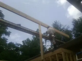 Carpenter setting a ridge beam over a new addition frame — Ice Dam Removal by Roofing Brothers in Warden