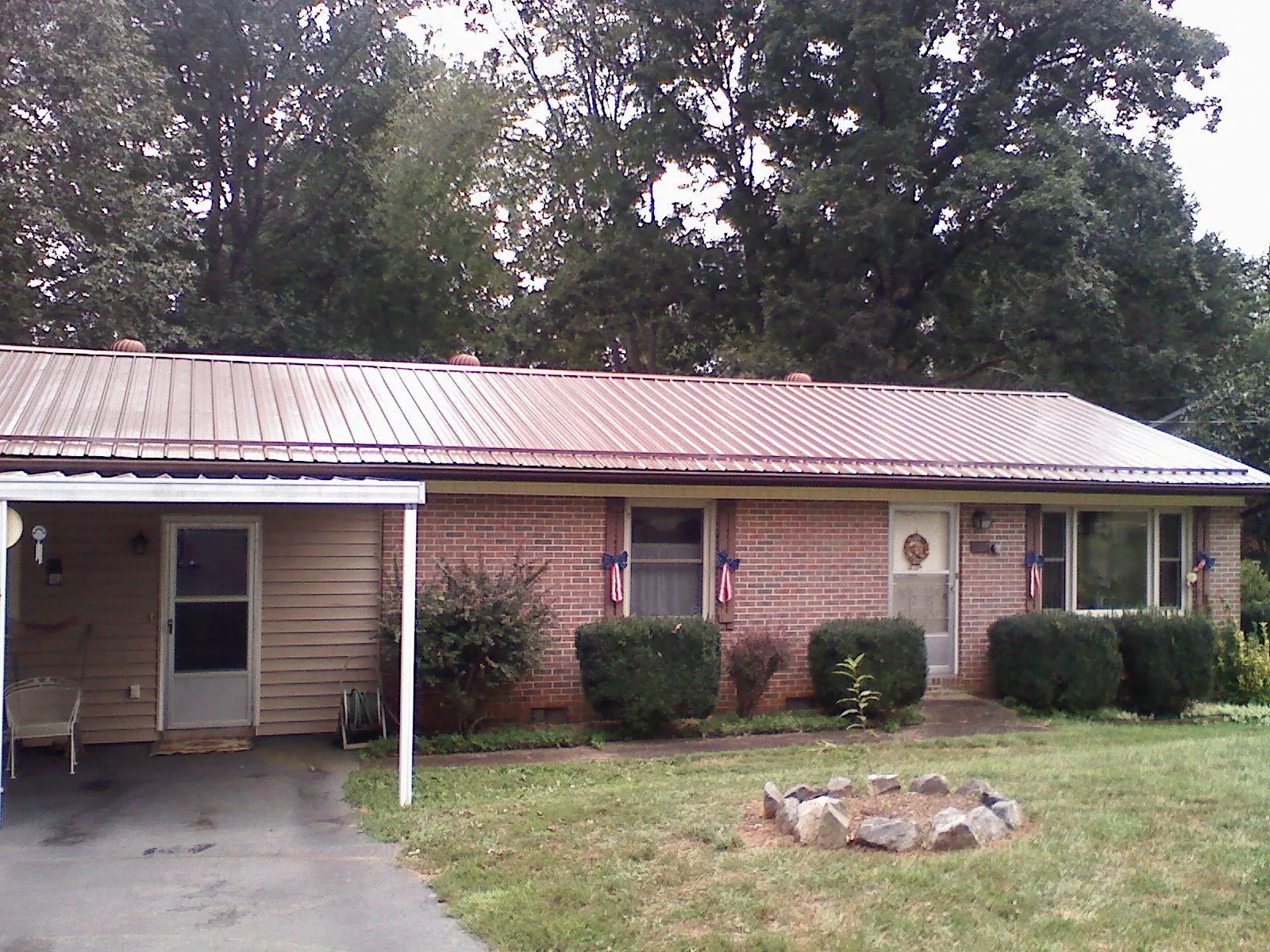 Bronze metal roof and carport on a brick ranch home — Roof Repair work by our crew in Warden
